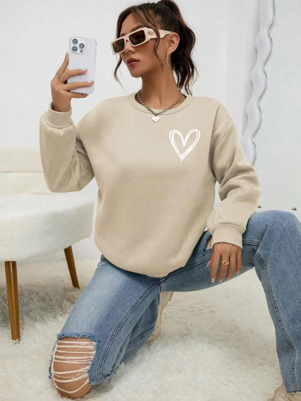 Women's casual crewneck sweatshirt with an all-over heart print pattern and soft fleece lining visible at the collar.