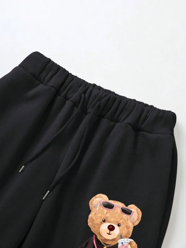 Woman models loose-fit sweatpants featuring cartoon bear print on the leg