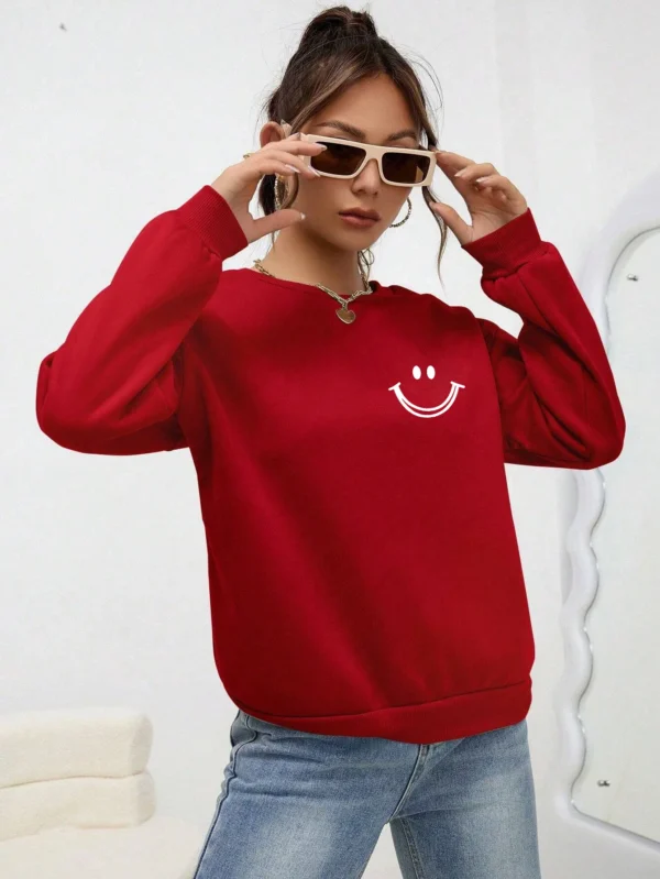 Women's O-neck fleece sweatshirt featuring a smiling face graphic print