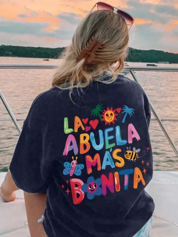 Women's white t-shirt with black text print reading 'La Abuela Más Bonita' (The Most Beautiful Grandmother).