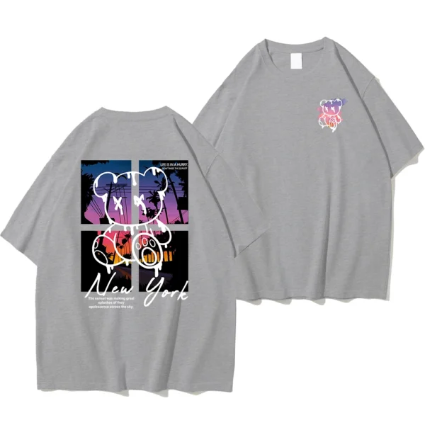 Men's loose fit cotton t-shirt displaying a colorful graphic print of a cartoon bear in front of a New York sunset scene.