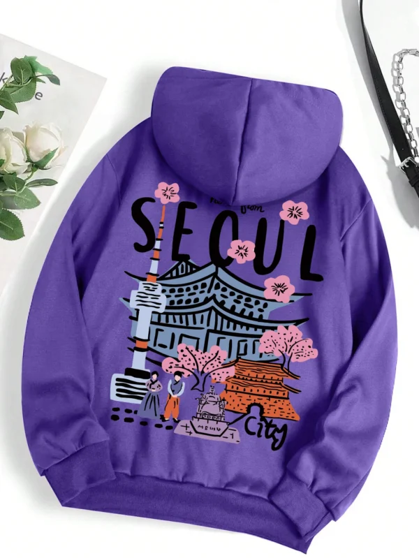 Woman wearing a comfortable warm fleece hoodie with a scenic Seoul print design and artificial fur lining visible inside the hood.
