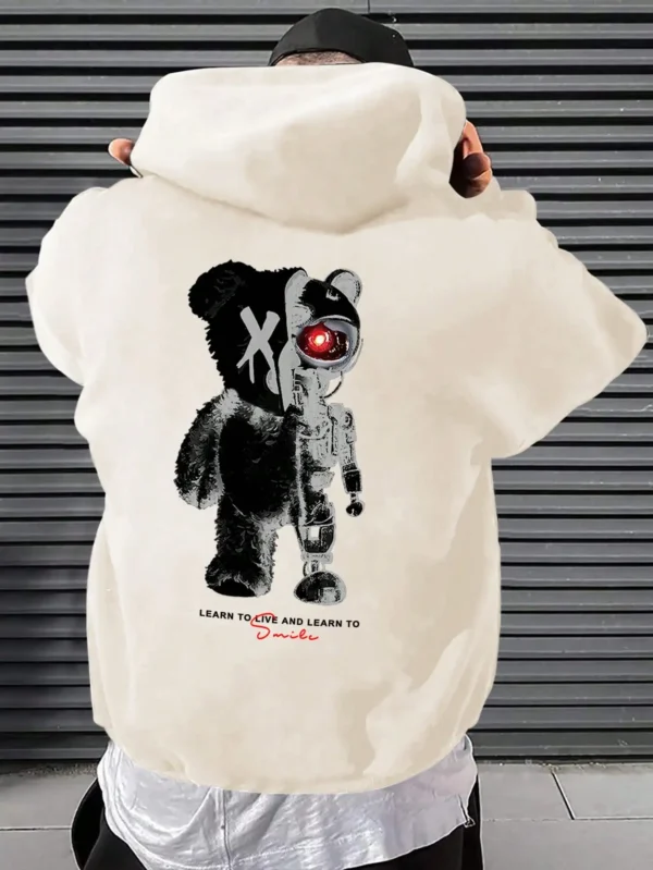 Man wearing a casual oversized black hoodie featuring a large white cartoon bear graphic print on the front.