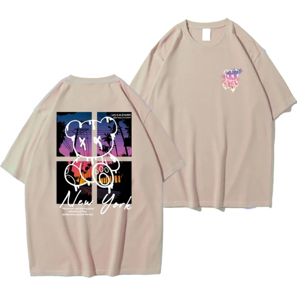 Men's loose fit cotton t-shirt displaying a colorful graphic print of a cartoon bear in front of a New York sunset scene.