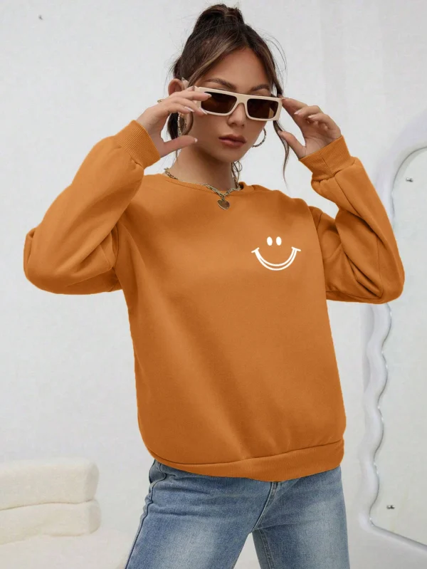 Women's O-neck fleece sweatshirt featuring a smiling face graphic print