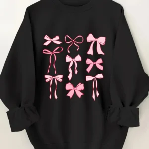 Woman wearing a pink hoodie with an all-over white bow print and fleece lining.