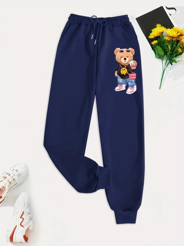 Woman models loose-fit sweatpants featuring cartoon bear print on the leg