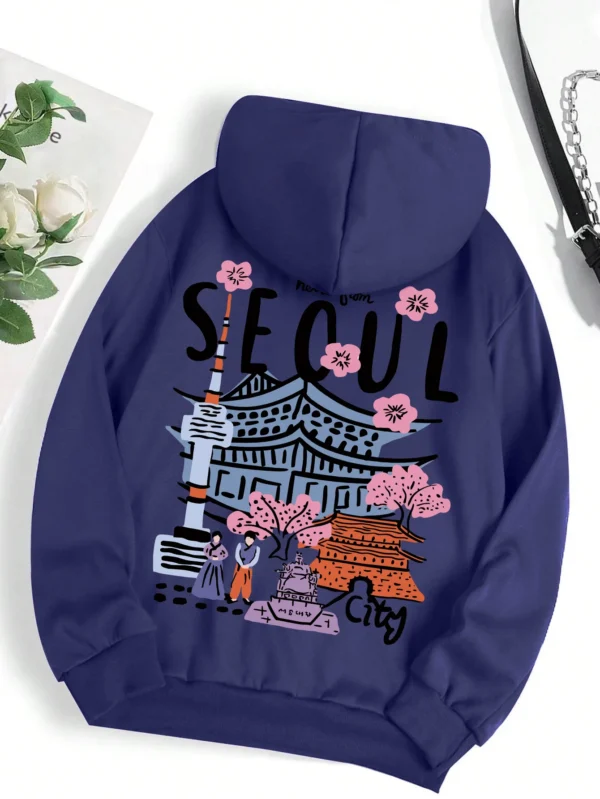 Woman wearing a comfortable warm fleece hoodie with a scenic Seoul print design and artificial fur lining visible inside the hood.