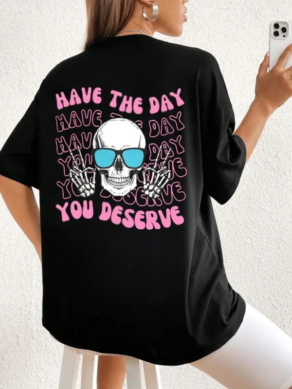 Woman wearing casual white t-shirt with black 'Have The Day You Deserve' graphic print.
