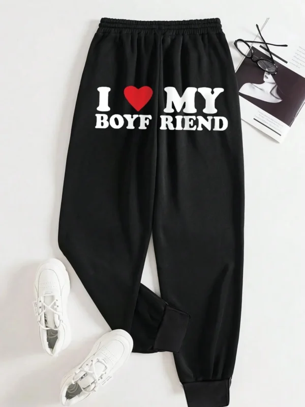 Women's black loose fit drawstring sweatpants with 'I Love My Boyfriend' white graphic print on the leg.