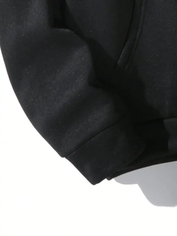 Man wearing a casual oversized black hoodie featuring a large white cartoon bear graphic print on the front.