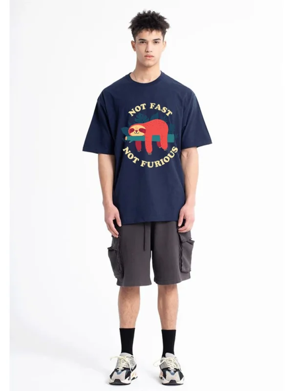 Model wearing funny 'Not Fast Not Furious' sloth graphic tee in breathable cotton. Unisex casual summer style.