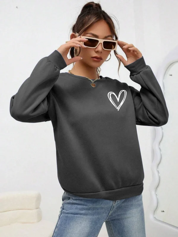Women's casual crewneck sweatshirt with an all-over heart print pattern and soft fleece lining visible at the collar.