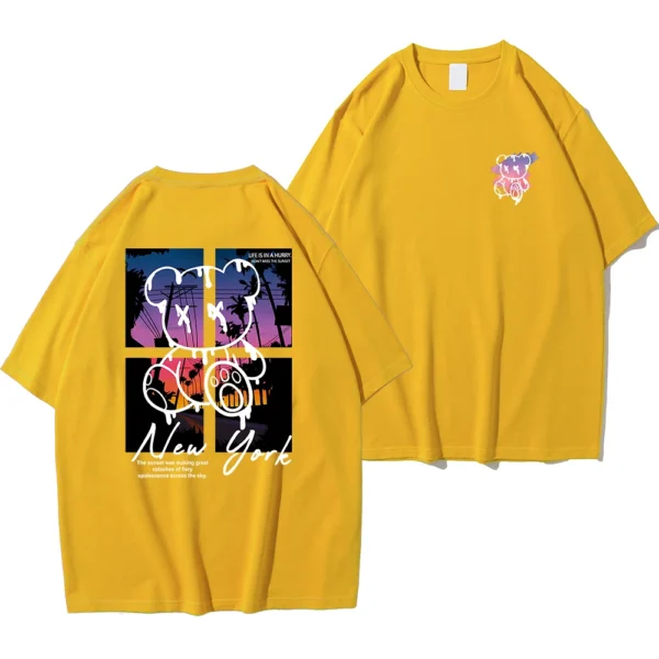 Men's loose fit cotton t-shirt displaying a colorful graphic print of a cartoon bear in front of a New York sunset scene.