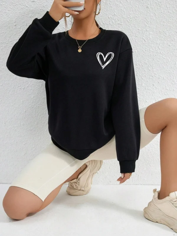 Women's casual crewneck sweatshirt with an all-over heart print pattern and soft fleece lining visible at the collar.