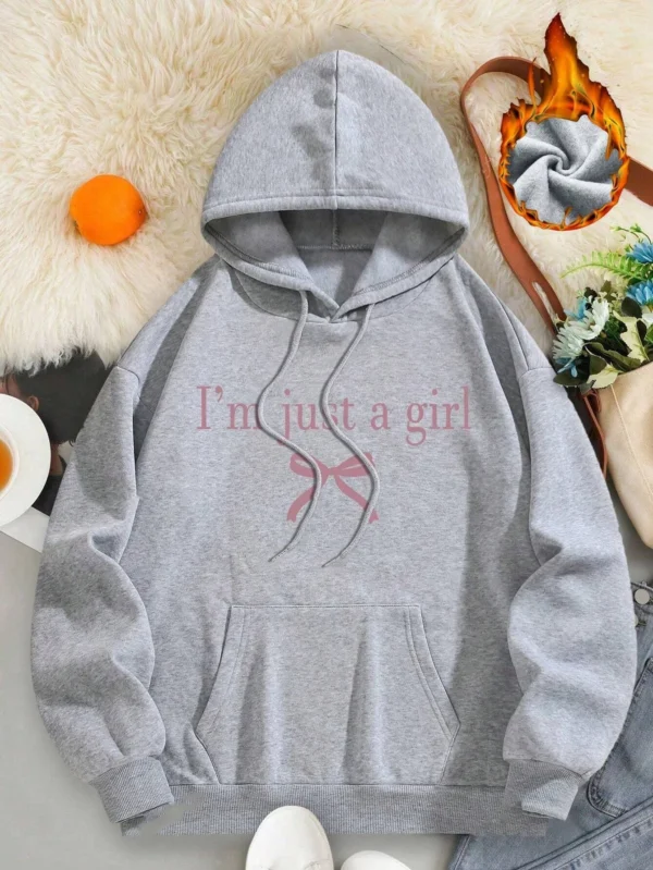 Woman wearing the warm fleece-lined 'I'm Just A Girl' pullover hoodie against a neutral background.