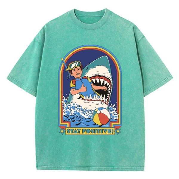 Woman wearing white O-neck t-shirt with colourful "Stay Positive" cartoon graphic print on the front.