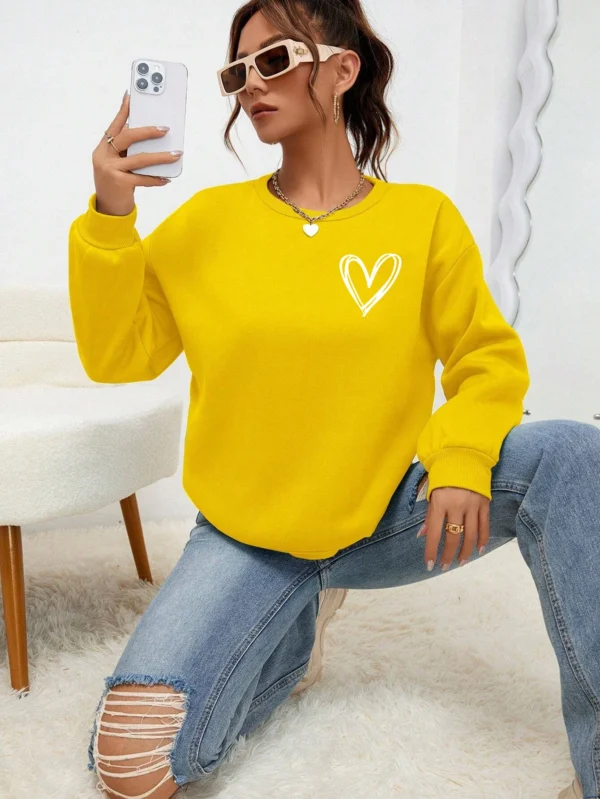 Women's casual crewneck sweatshirt with an all-over heart print pattern and soft fleece lining visible at the collar.