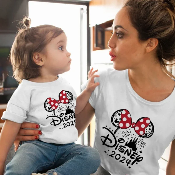 Family wearing matching Mickey and Minnie Mouse cotton shirts and baby romper for Disney trip.