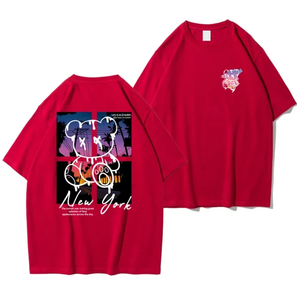 Men's loose fit cotton t-shirt displaying a colorful graphic print of a cartoon bear in front of a New York sunset scene.