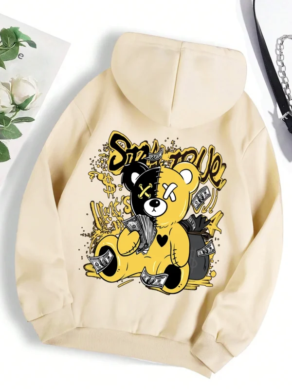 Woman wearing oversized fleece hoodie with large bear cartoon print - Harajuku streetwear style.
