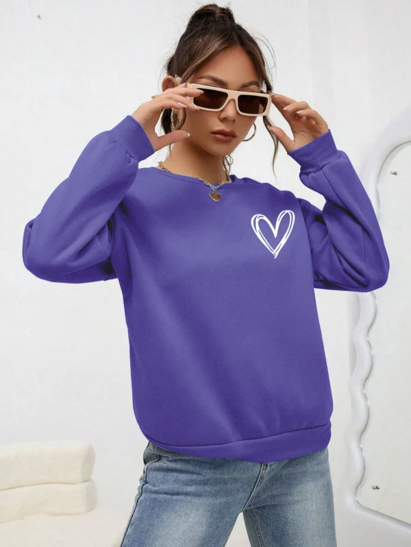 Women's casual crewneck sweatshirt with an all-over heart print pattern and soft fleece lining visible at the collar.