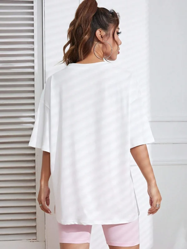Woman wearing a soft white t-shirt with a colorful retro 'Take Me Back 90s' graphic print.
