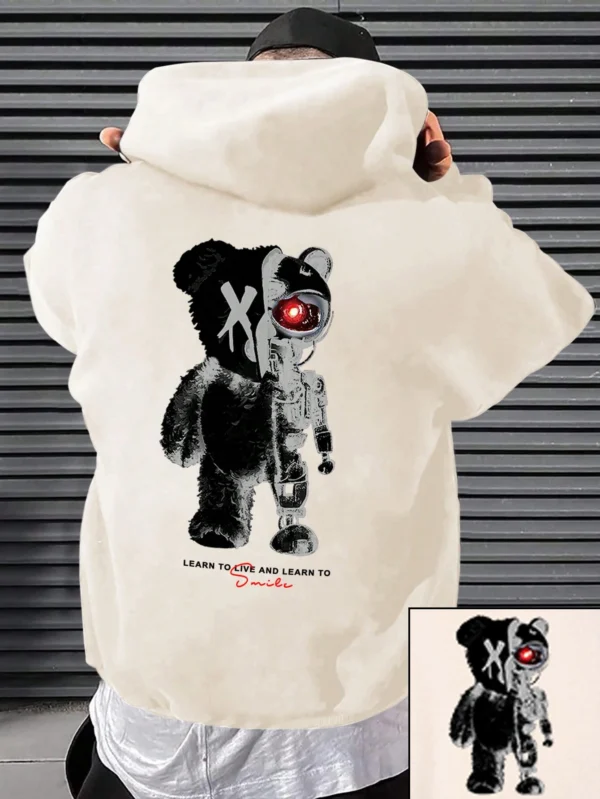 Man wearing a casual oversized black hoodie featuring a large white cartoon bear graphic print on the front.