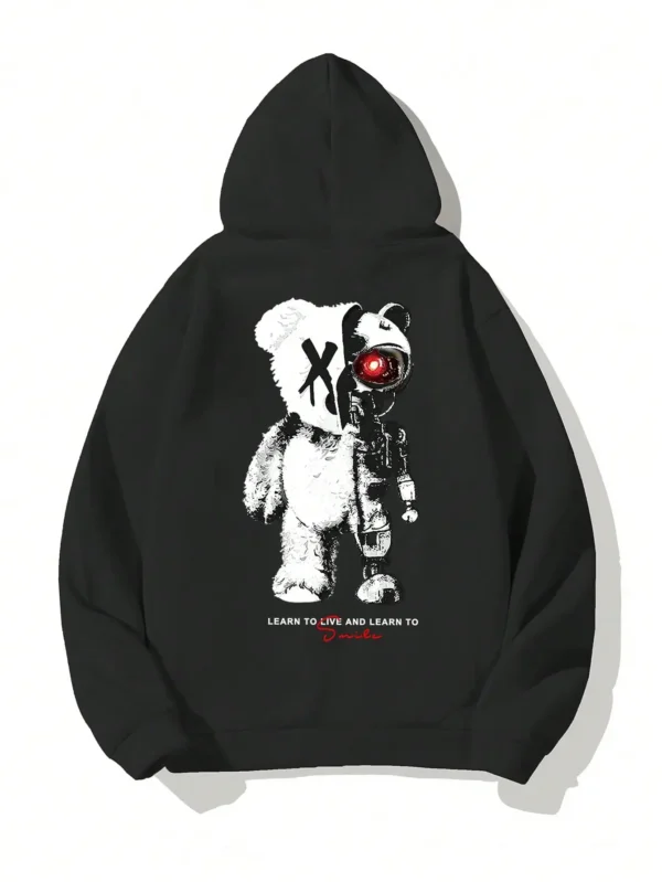 Man wearing a casual oversized black hoodie featuring a large white cartoon bear graphic print on the front.