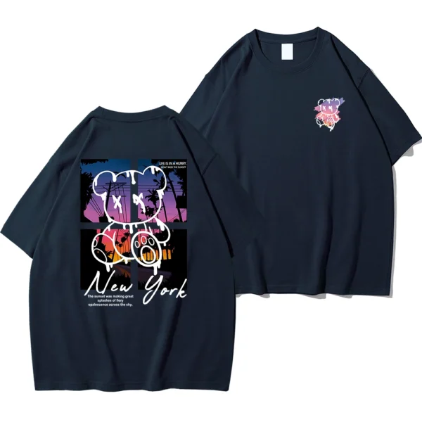 Men's loose fit cotton t-shirt displaying a colorful graphic print of a cartoon bear in front of a New York sunset scene.