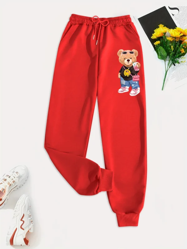 Woman models loose-fit sweatpants featuring cartoon bear print on the leg