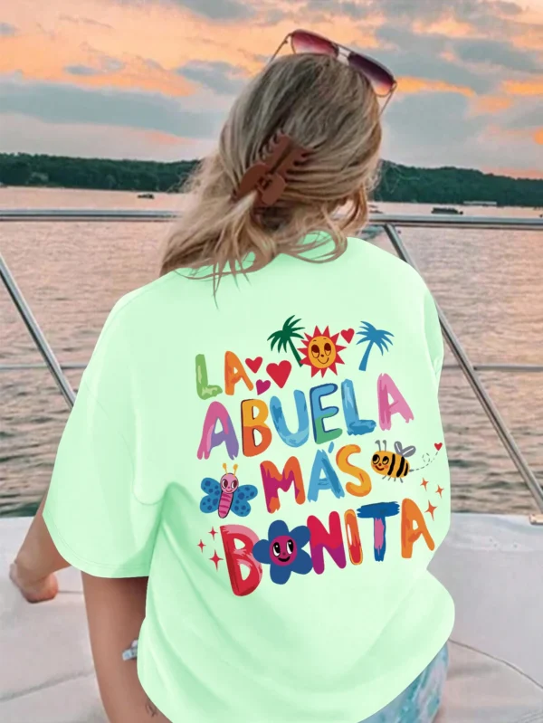 Women's white t-shirt with black text print reading 'La Abuela Más Bonita' (The Most Beautiful Grandmother).
