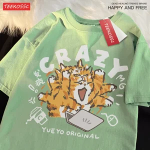 Woman wearing a light green loose-fit cotton t-shirt with a funny orange cat print and shoulder drop sleeves.