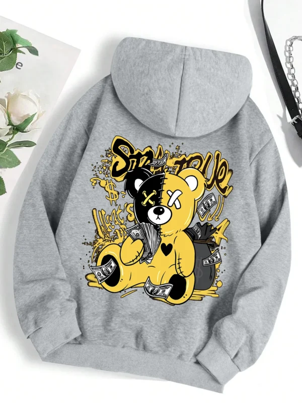 Woman wearing oversized fleece hoodie with large bear cartoon print - Harajuku streetwear style.