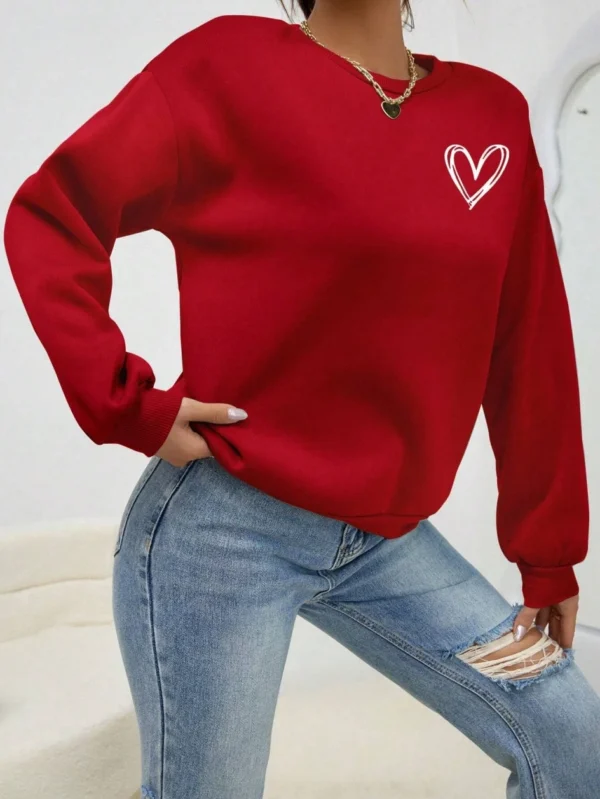 Women's casual crewneck sweatshirt with an all-over heart print pattern and soft fleece lining visible at the collar.