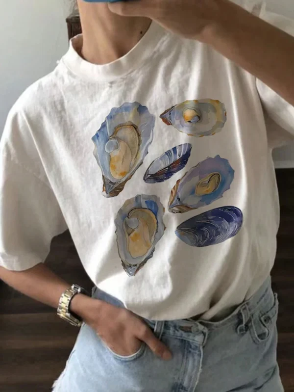 Woman wearing a casual white t-shirt with a blue and beige vintage seashell print.
