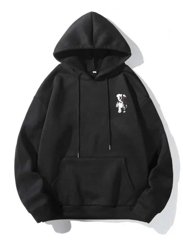 Man wearing a casual oversized black hoodie featuring a large white cartoon bear graphic print on the front.