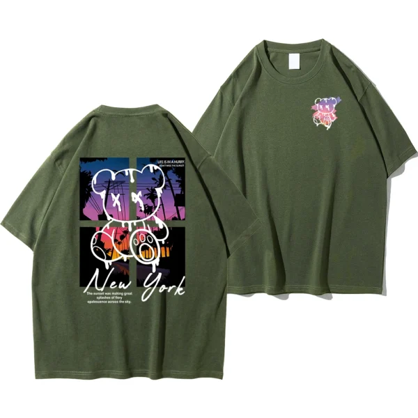 Men's loose fit cotton t-shirt displaying a colorful graphic print of a cartoon bear in front of a New York sunset scene.