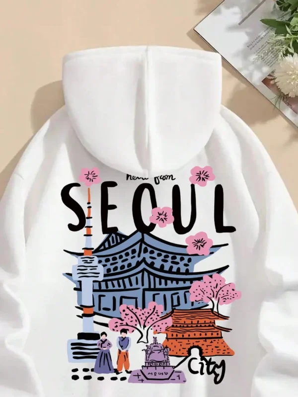 Woman wearing a comfortable warm fleece hoodie with a scenic Seoul print design and artificial fur lining visible inside the hood.