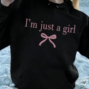 Woman wearing the warm fleece-lined 'I'm Just A Girl' pullover hoodie against a neutral background.