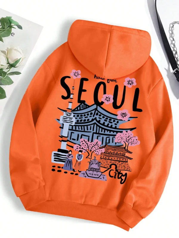 Woman wearing a comfortable warm fleece hoodie with a scenic Seoul print design and artificial fur lining visible inside the hood.