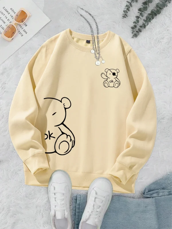 Women's retro beige fleece hoodie with a cute Kawaii teddy bear 'OK' print graphic on the front.