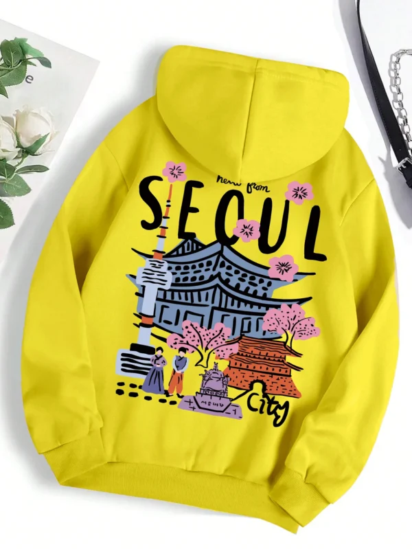 Woman wearing a comfortable warm fleece hoodie with a scenic Seoul print design and artificial fur lining visible inside the hood.